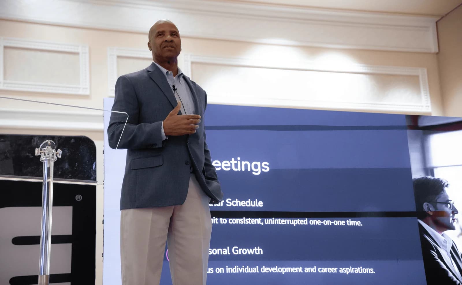 Rutherford Pascal presenting beside a slide screen in a hotel ballroom