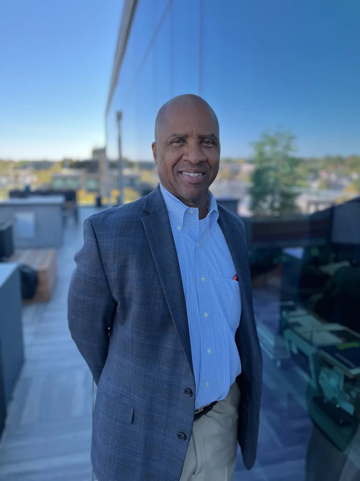 Rutherford Pascal outdoors on a rooftop terrace, smiling at the camera
